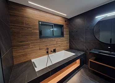 Salle de bain avec baignoire et grand miroir