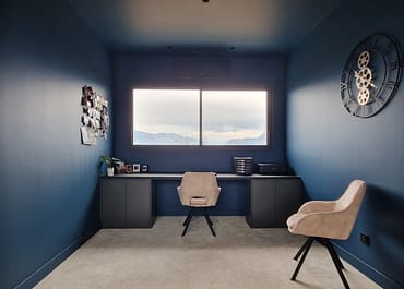 Réalisation d'un espace bureau avec mur bleu, chaises et bureau vu de près